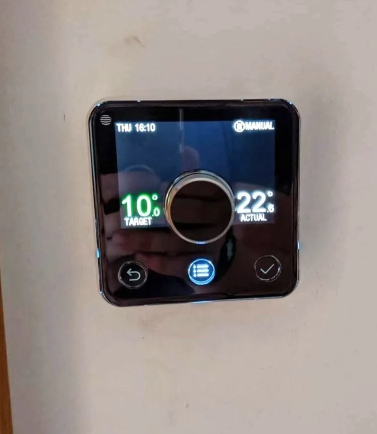 Smart heating thermostat mounted on a wall